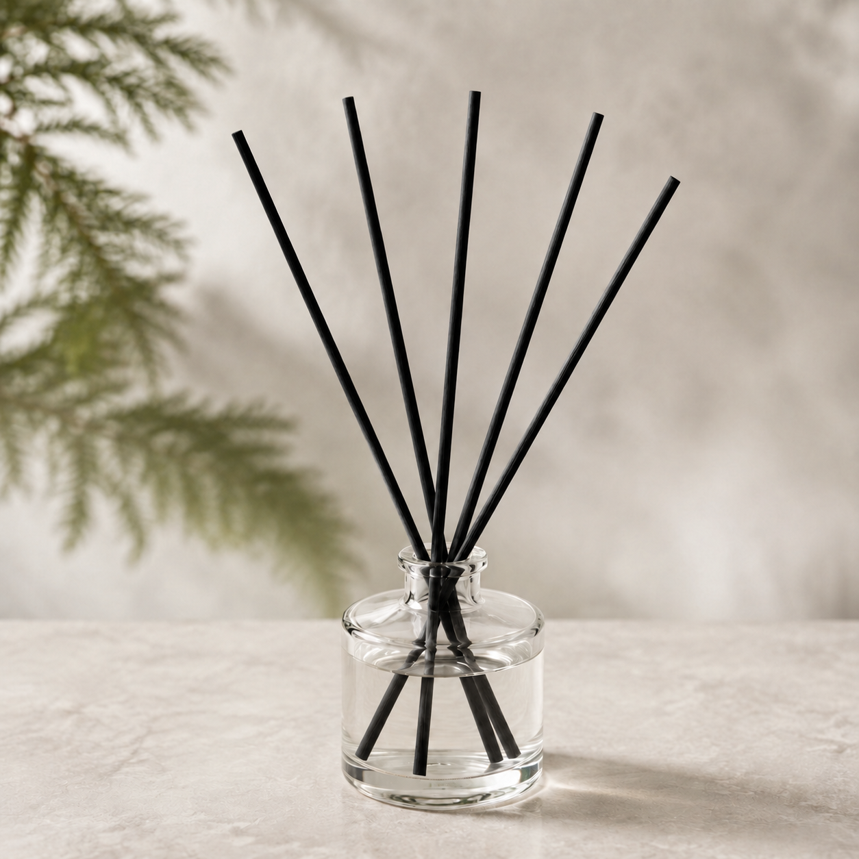 Pacific Northwest Reed Diffuser with black reeds styled beside evergreen branches