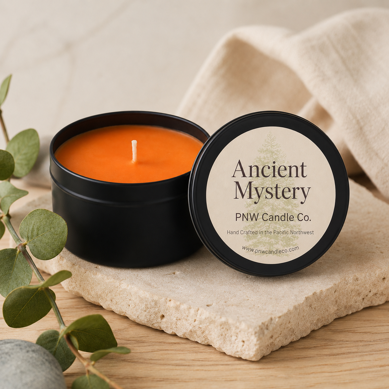 Ancient Mystery scented candle by PNW Candle Co, featuring a rustic glass jar and a flickering flame, emitting a warm glow.