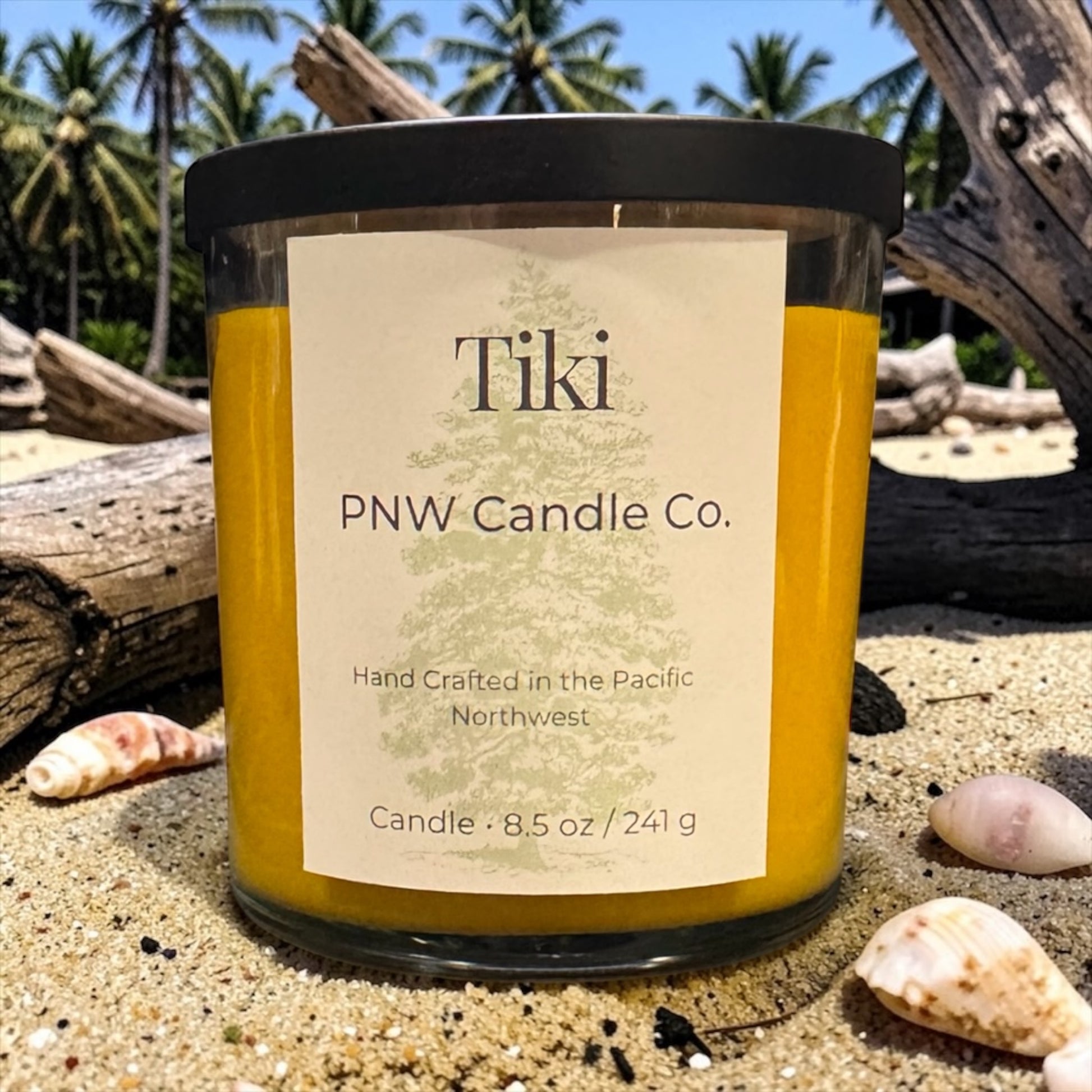 PNW Candle Co Tiki Scented Candle in a glass jar with a lit wick, showcasing a tropical-inspired candle aroma.