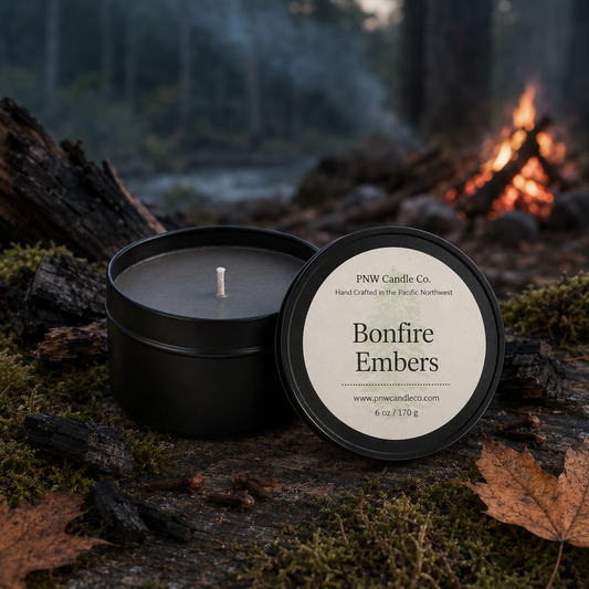 Bonfire Embers 6 oz smoky gray wax candle tin by PNW Candle Co. with charred wood, moss, maple leaves, cloves, and a twilight campfire