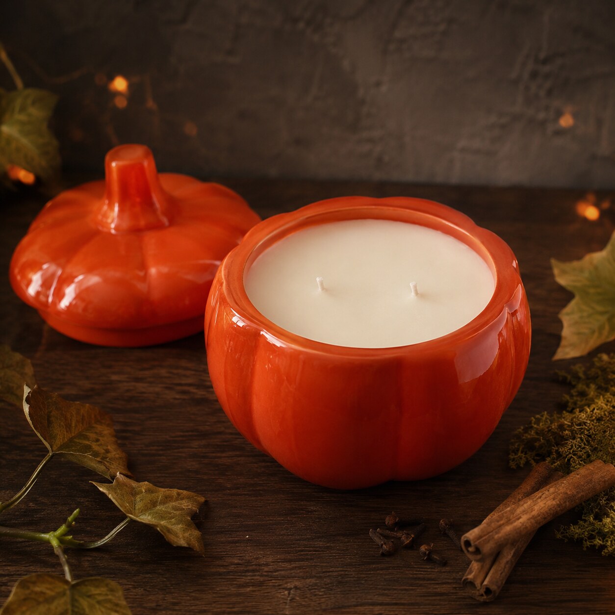 Open Cashmere Pumpkin 15 oz candle showing ivory coconut apricot wax and two cotton wicks beside its orange ceramic pumpkin lid.