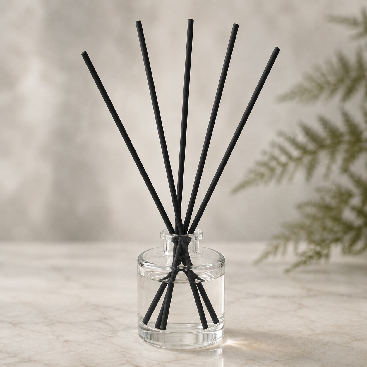 Pacific Northwest Reed Diffuser with black rattan reeds in a clear round glass vessel